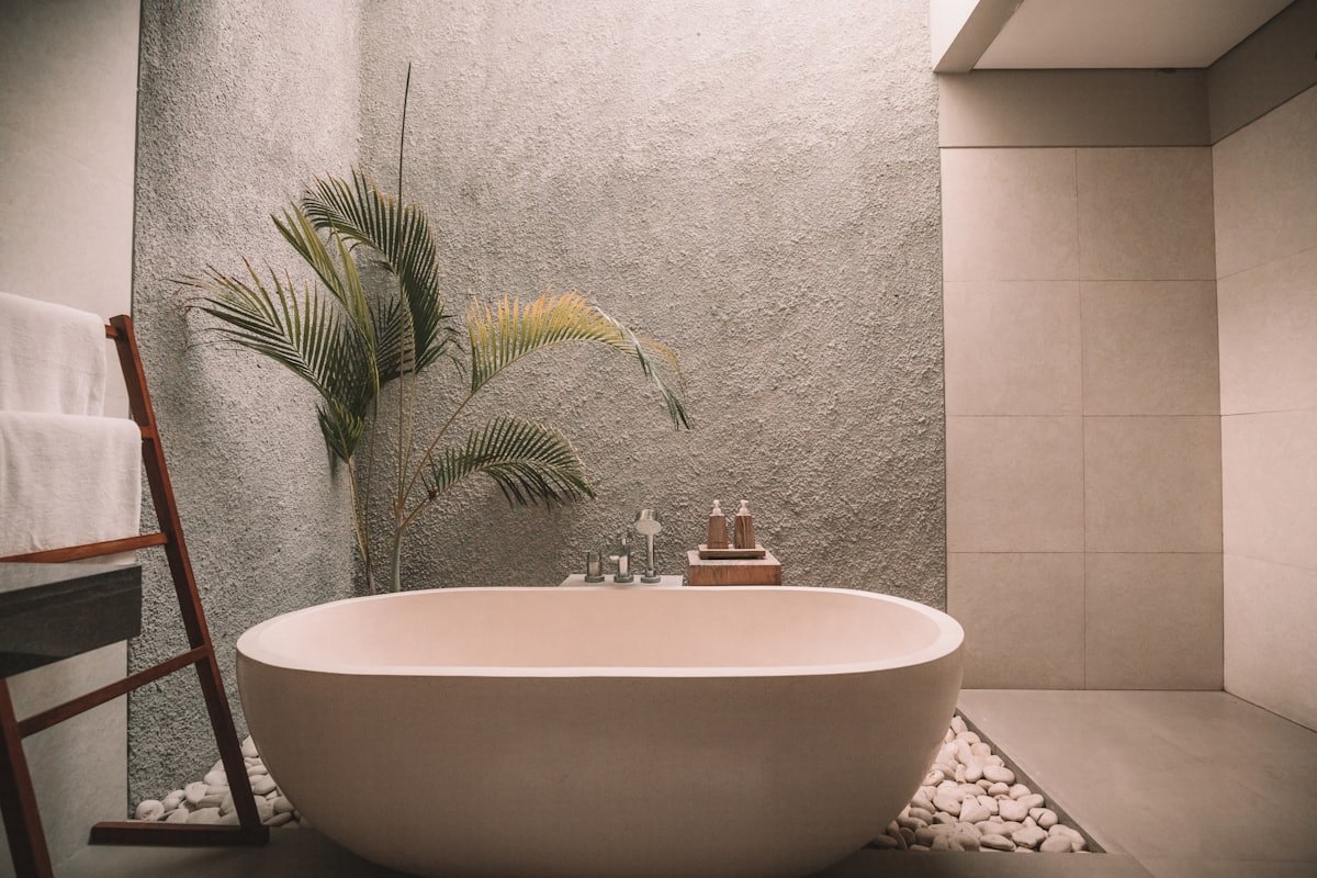 Vasca da bagno di design in una SPA minimale con pianta e ciottoli